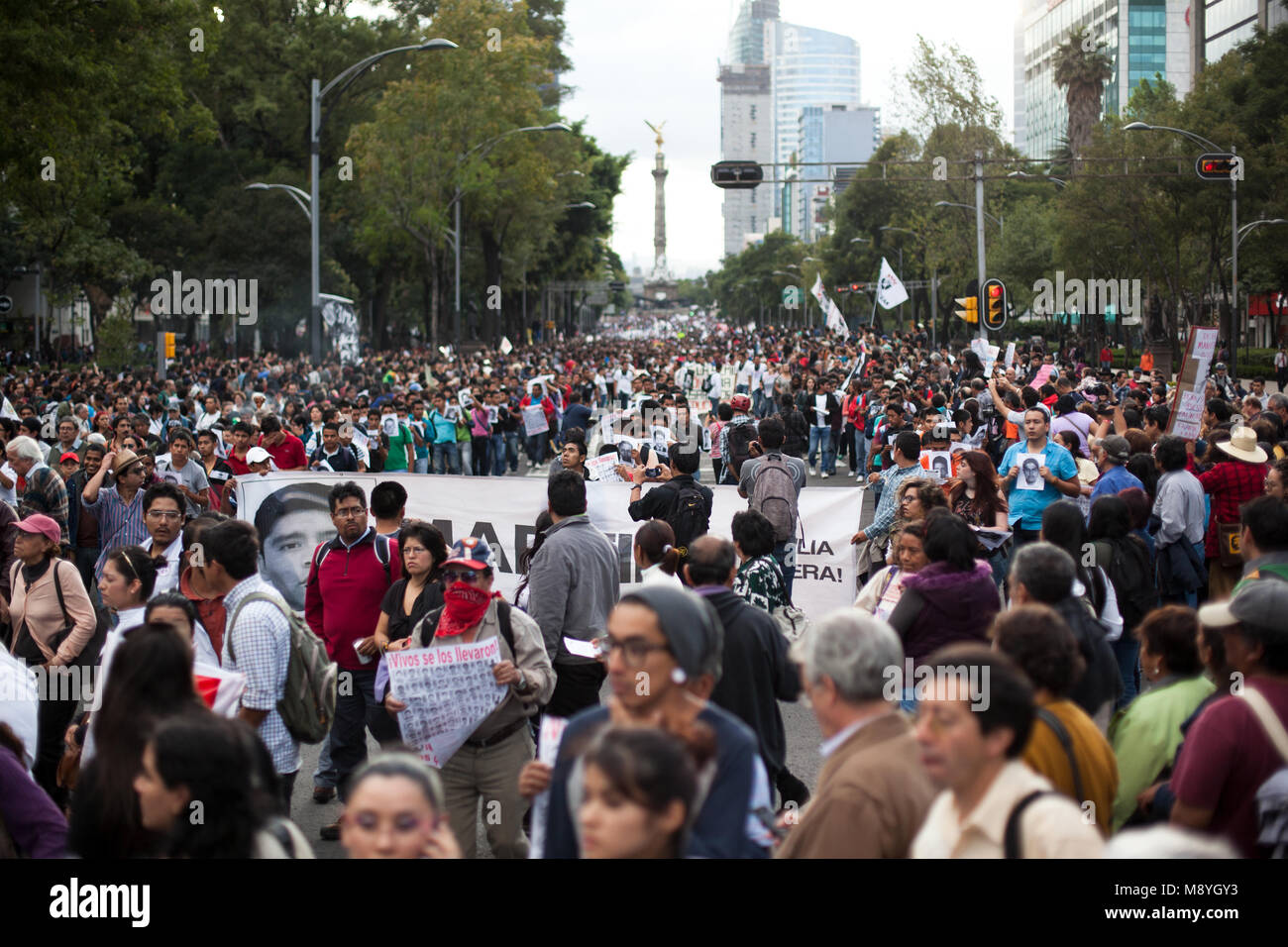 People march through Mexico City protesting for the return of 43 missing Normalista students who were taken from Ayotzinapa teaching college in Iguala, Mexico, during the 'Global Day of Action for Ayotzinapa' on Wednesday, October 23, 2014.  Three students were killed and 43 more have been missing since September 26, 2014. The local mayor and his wife were accused of ordering the kidnappings and killings. The local police were also accused of working with the Guerreros Unidos cartel in the crimes. Stock Photo