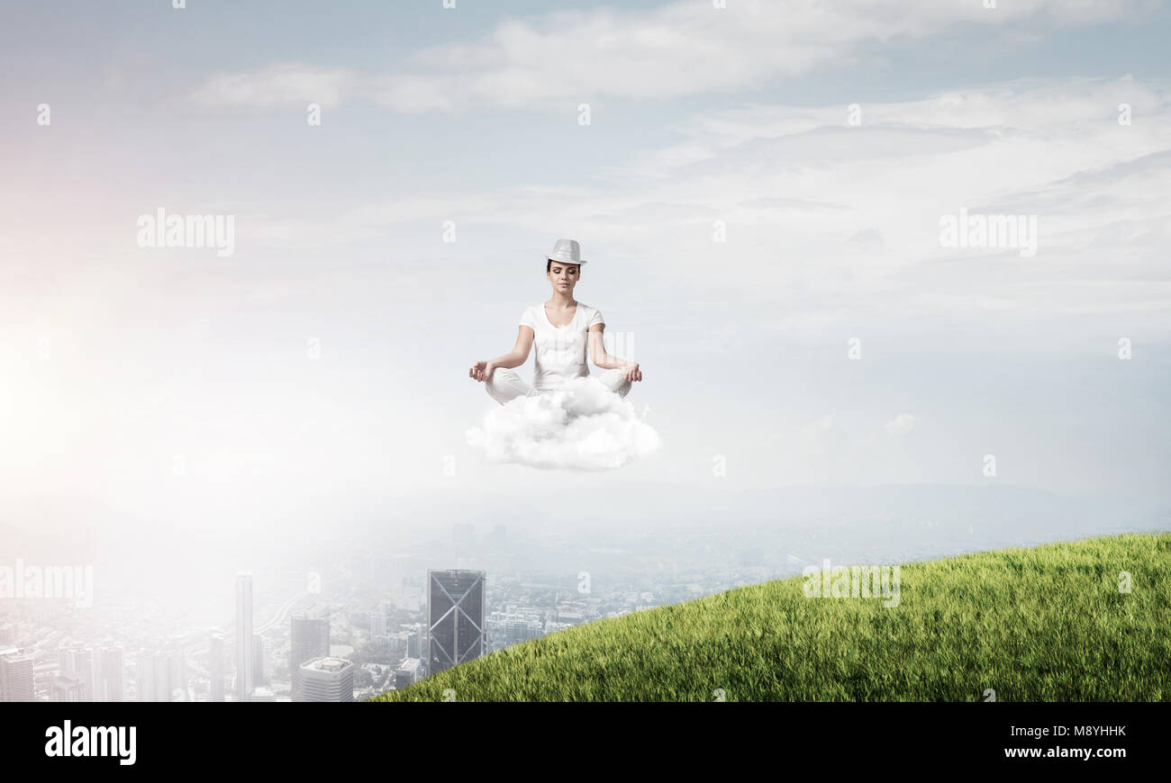Young woman in white clothing keeping eyes closed and looking ...