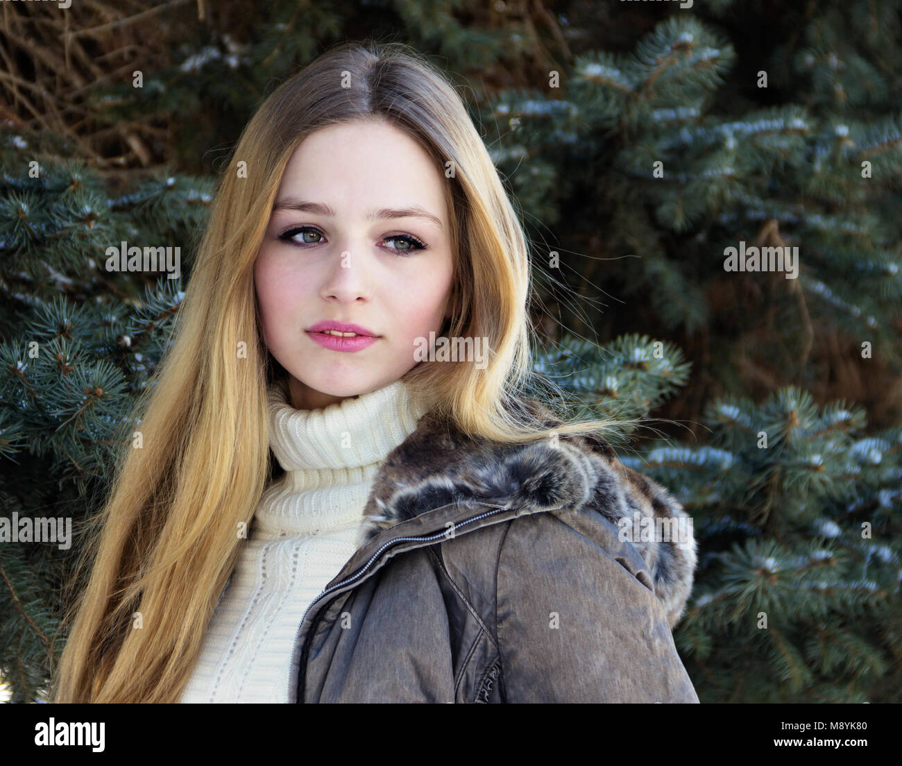 Portrait of a very beautiful Russian teen girl on the background of spruce. Stock Photo
