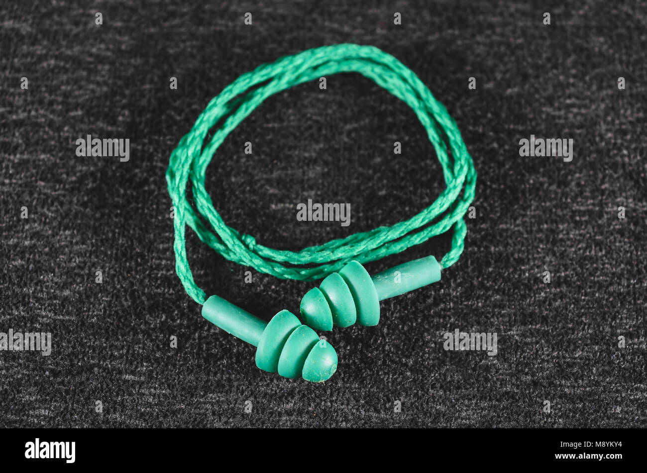 Rubber ear plugs for noise isolation. Green ear plug with cord Stock