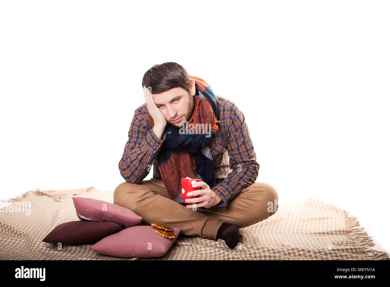 healthcare, people and medicine concept - ill man with flu coughing and drinking hot tea from cup at home. Stock Photo