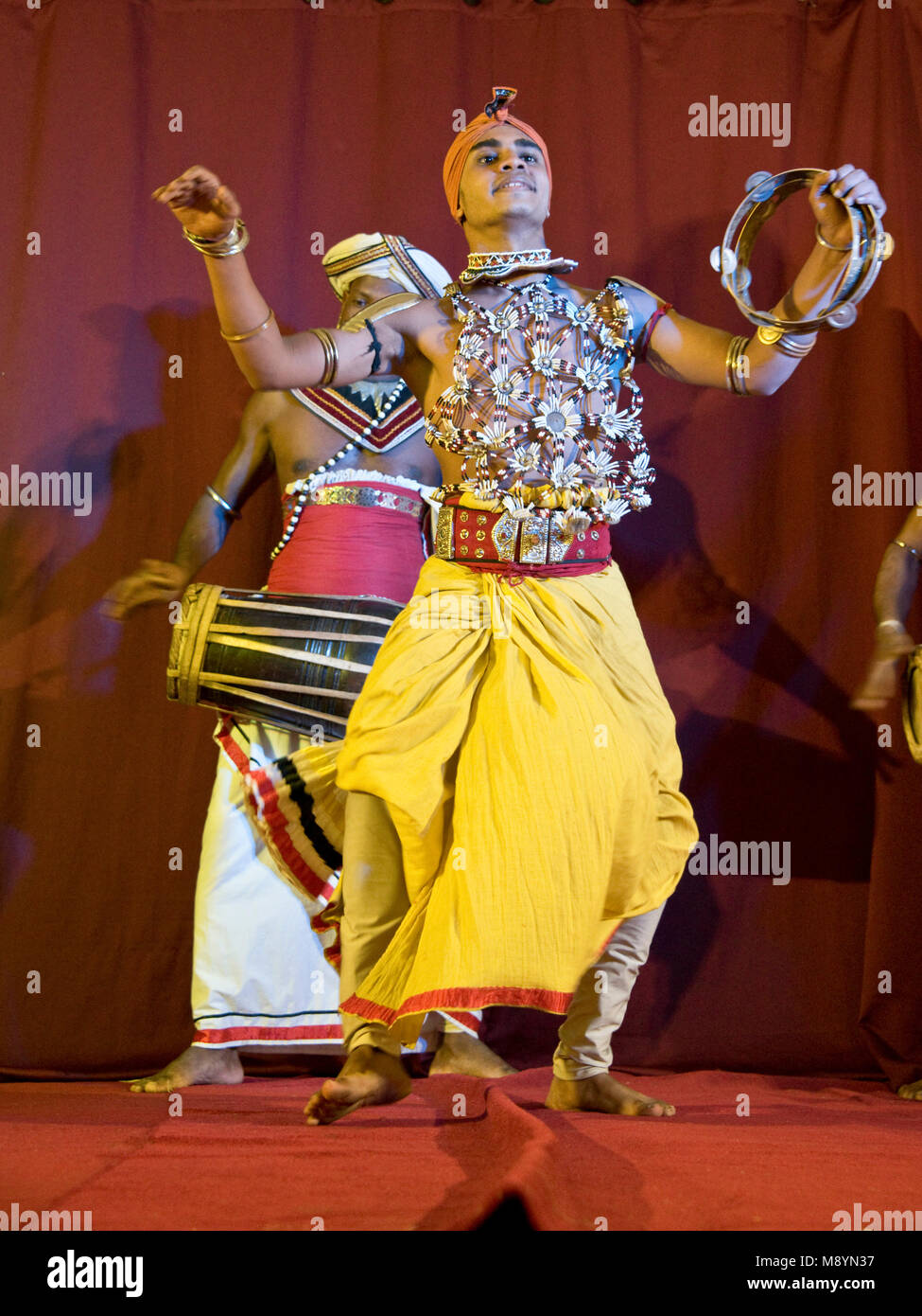 Traditional colourful Sri Lankan dancers and musicians at a display.  Slow shutter speed so motion blur. Stock Photo