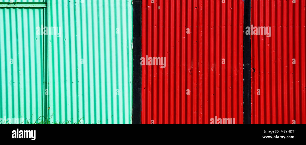Brightly coloured corrugated fence. Bright colours. Colors. Corrugations. Fencing. Red. Blue. Turquoise. Stock Photo