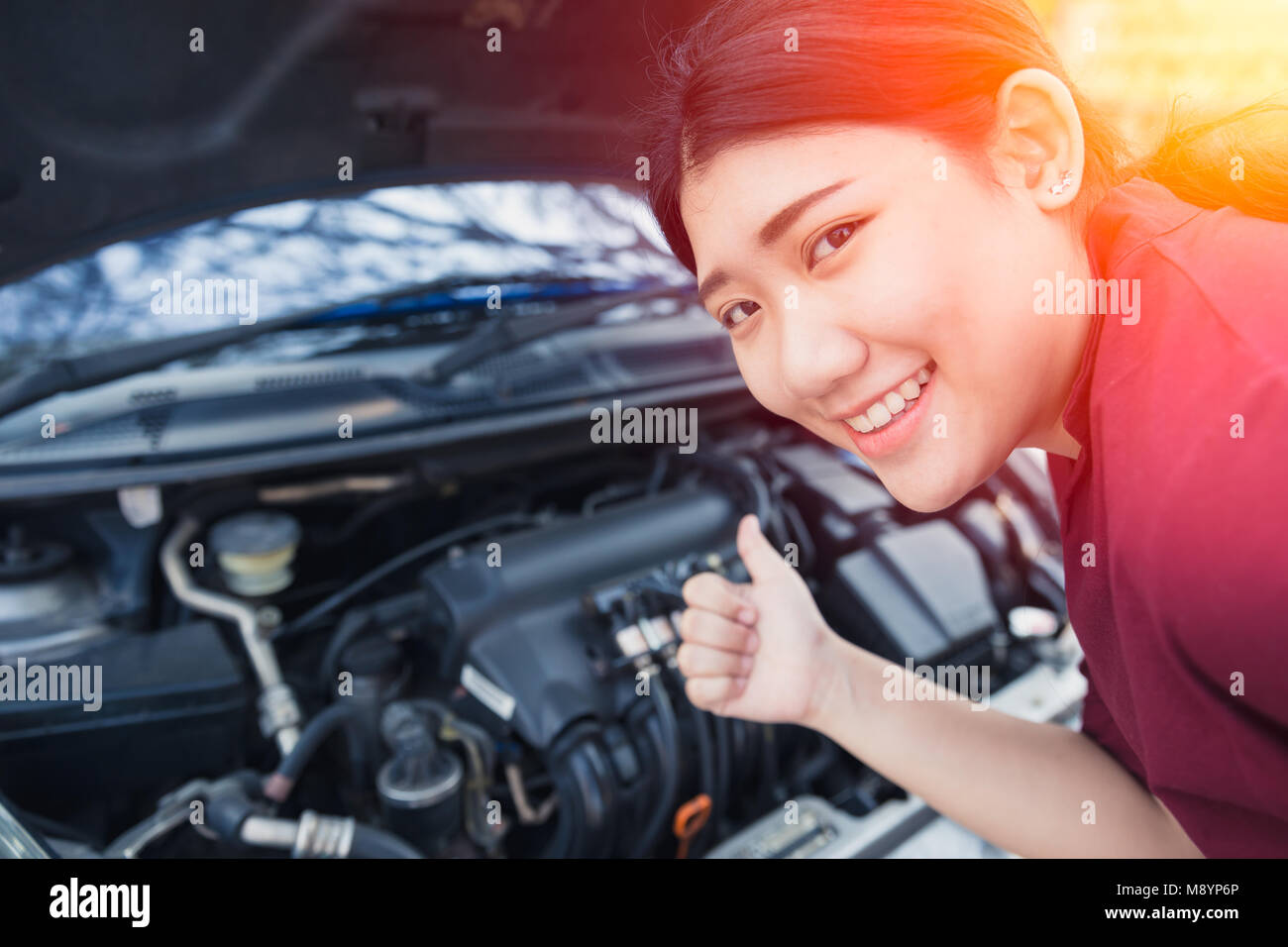 Asian women thumbs up good car engine check up before go trip Stock Photo