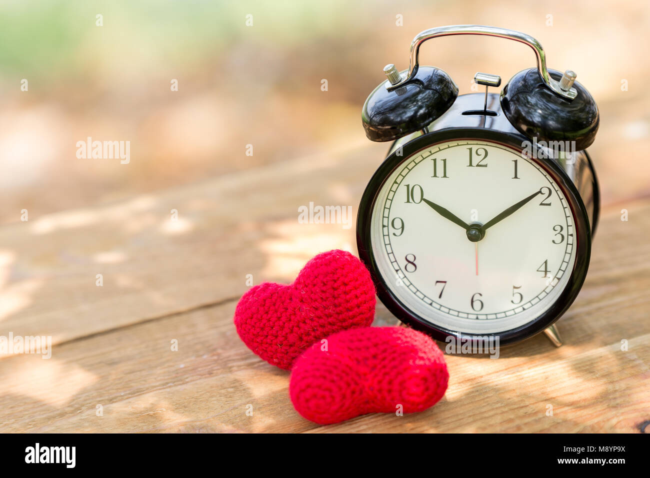 Love clock with heart on wooden table day light times Stock Photo Alamy