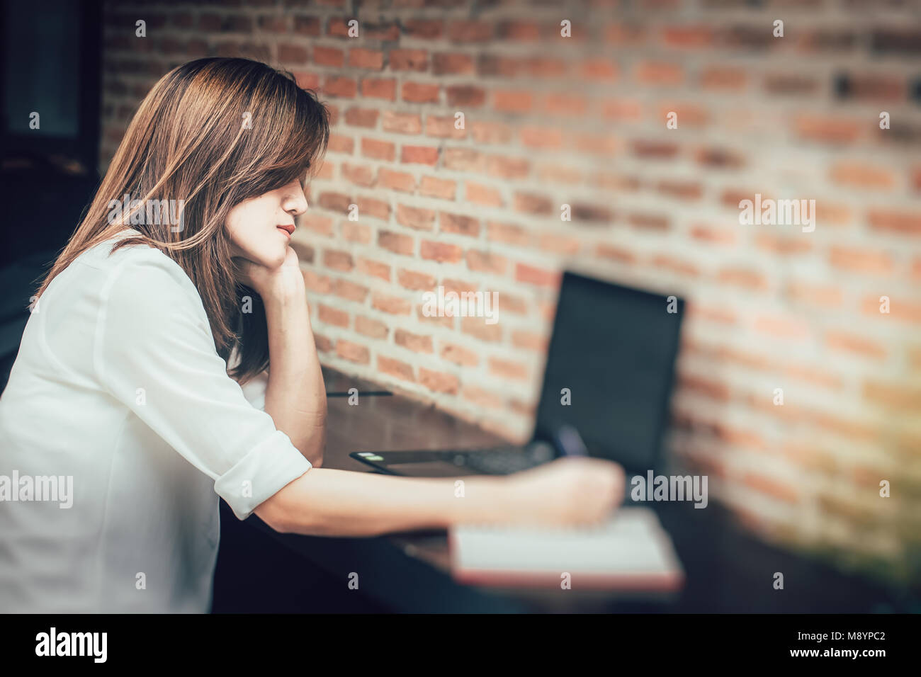 Fatigue Women Thinking alone while working and take a note Stock Photo