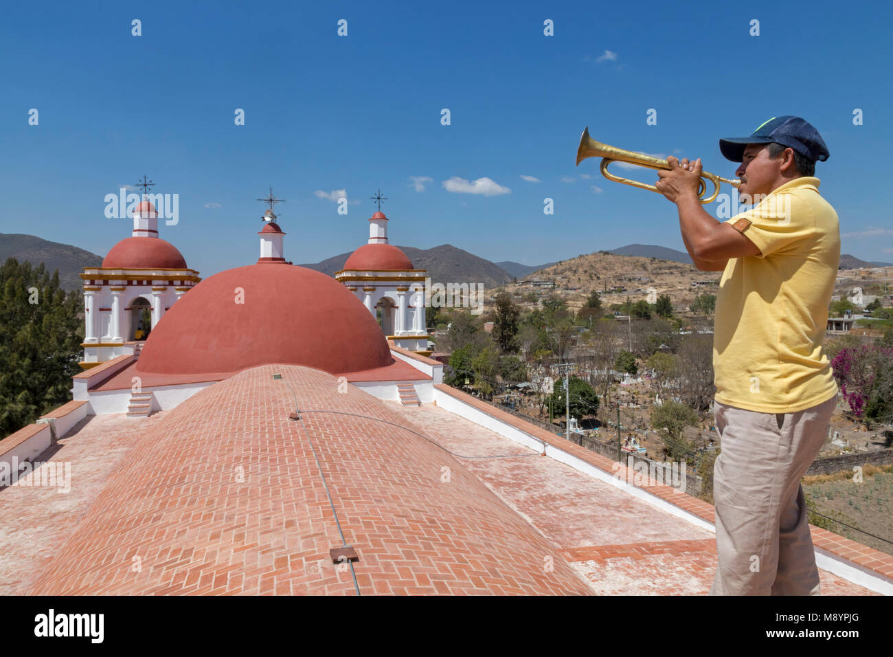 San Juan Teitipac, Oaxaca, Mexico - A man plays a bugle on the roof of the 16th century Dominican church in a small Zapotec town. Stock Photo