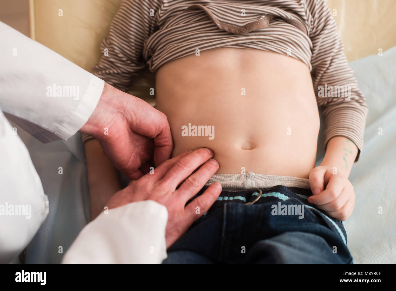 kid-doctor-touch-belly-of-small-patient-with-fingers-pediatrician-M8YR0F.jpg