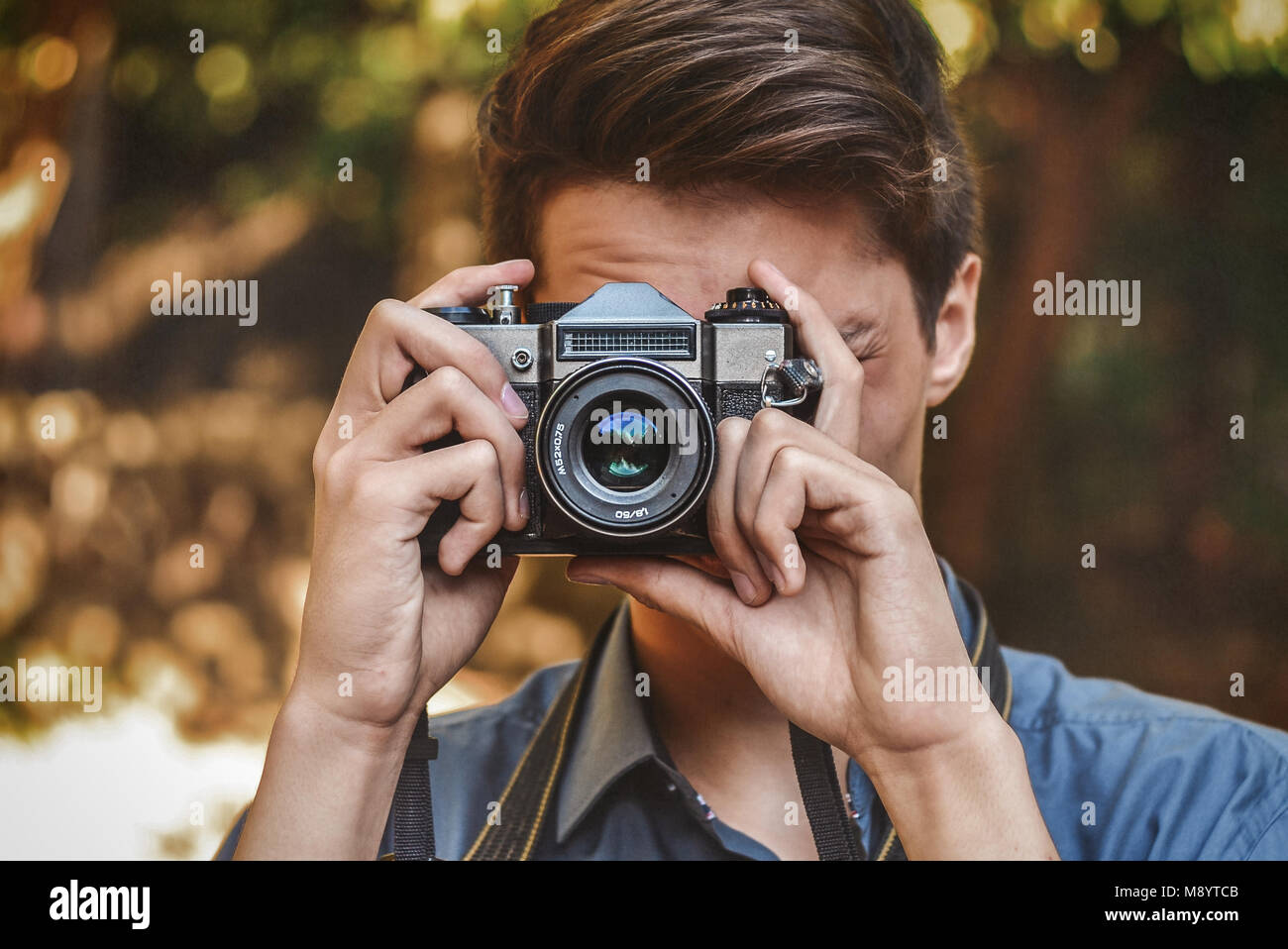 Young hipster photographer with retro film photo camera Stock Photo