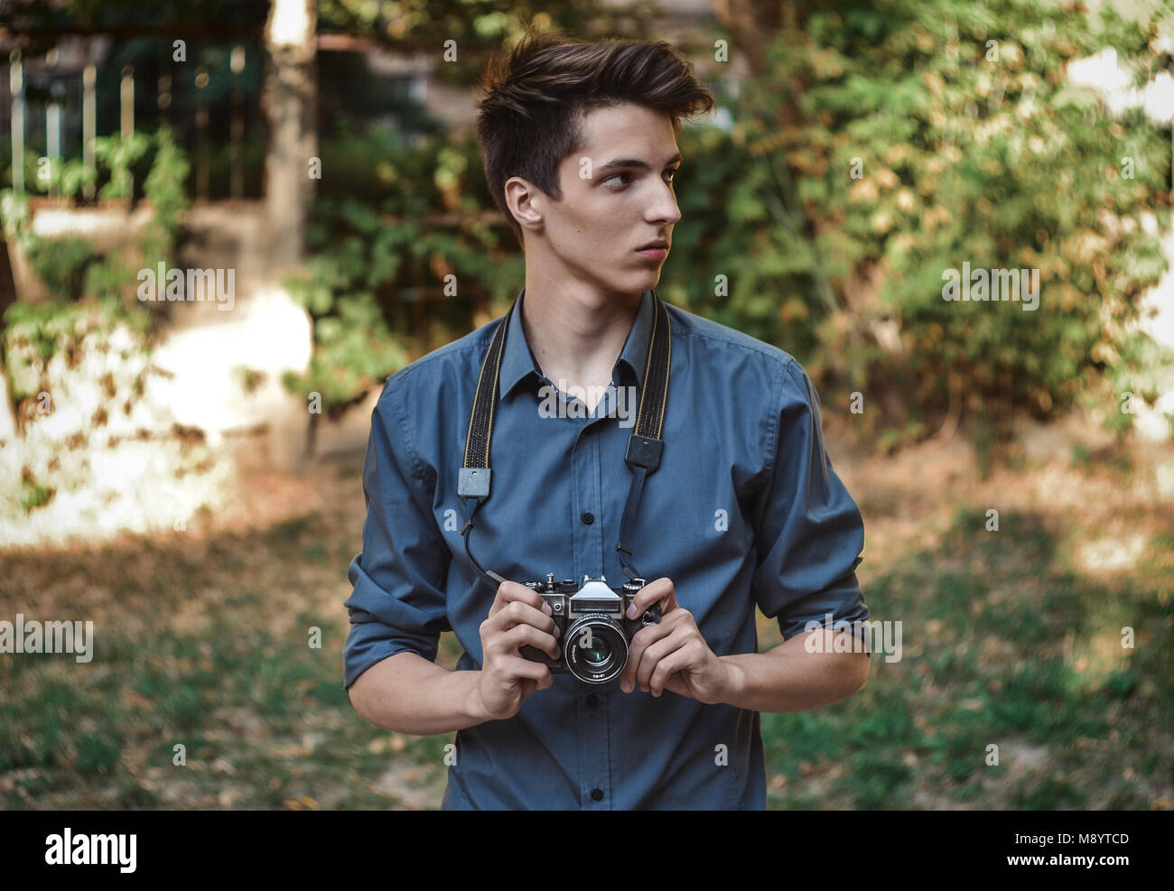 Hipster teenager boy photographer with retro film photo camera Stock Photo
