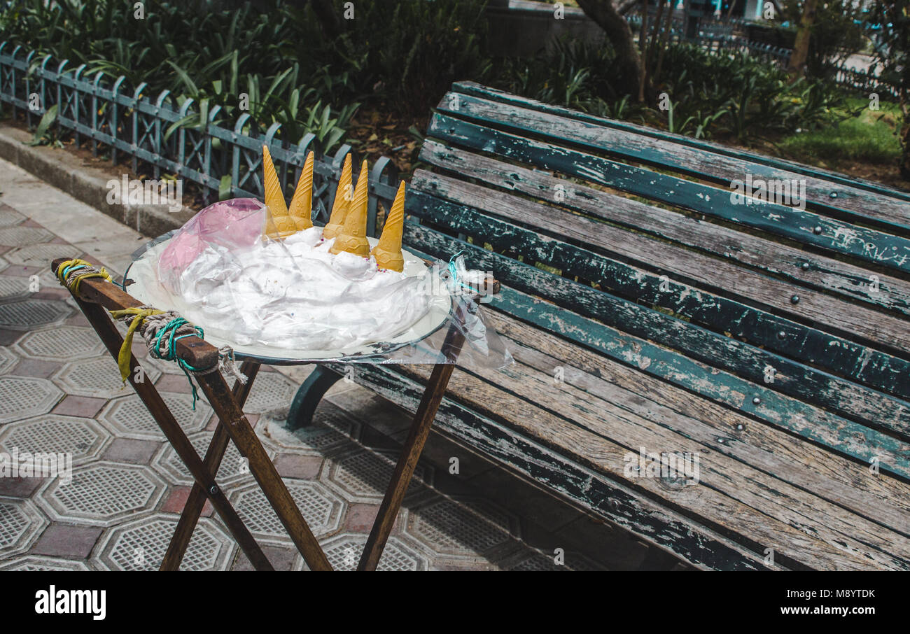 Ecuadorian street food stand by a park bench for traditional guanaba and strawberry Espumilla, a meringue cream similar to ice cream that doesn't melt Stock Photo