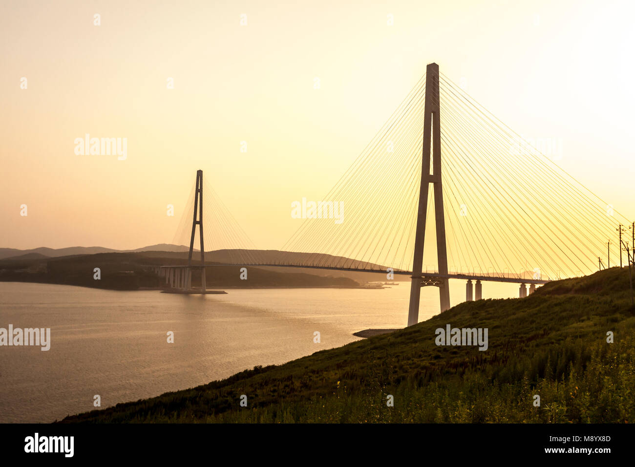 Cable-stayed bridge 'Russky Bridge' to island Russkiy on the sunset. Vladivostok, Primorsky Krai, Russia Stock Photo