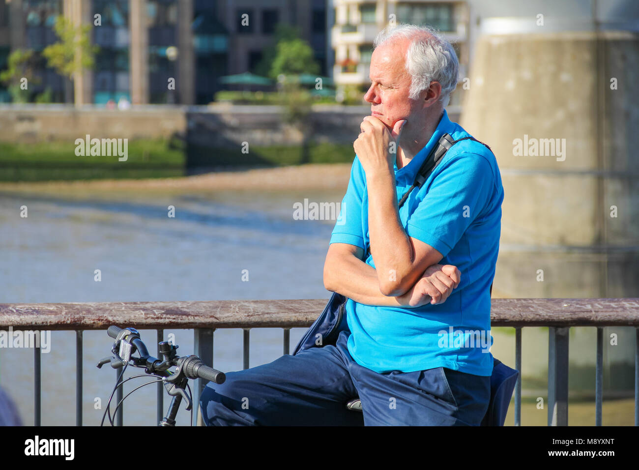 London, UK - July 09, 2017 - A grey-haired man looking over the riverside at South Bank in a hot weather Stock Photo