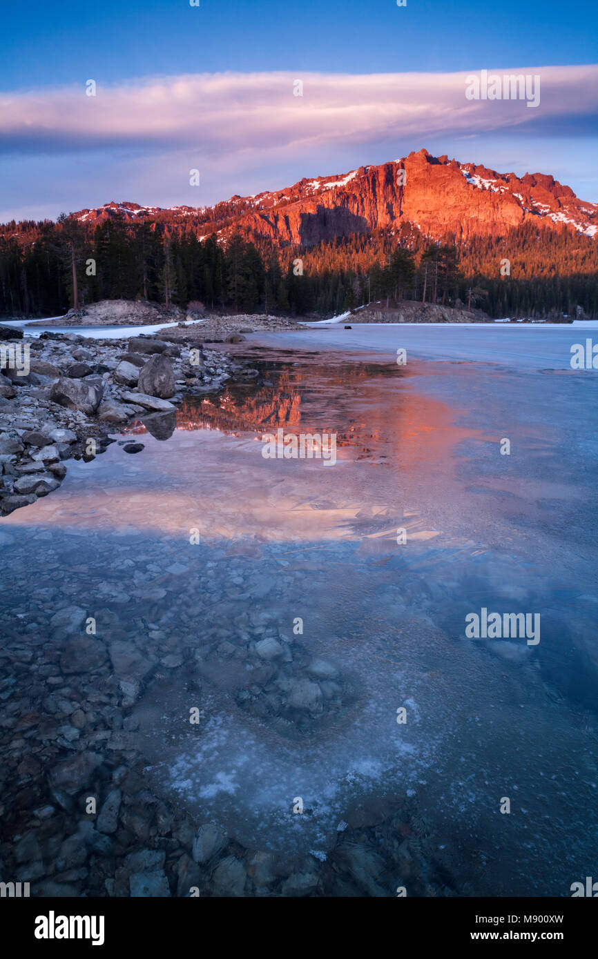 A partially frozen Silver Lake with Thunder Mountain in the background at sunset in Kit Carson, Eldorado National Forest, California, USA. Stock Photo