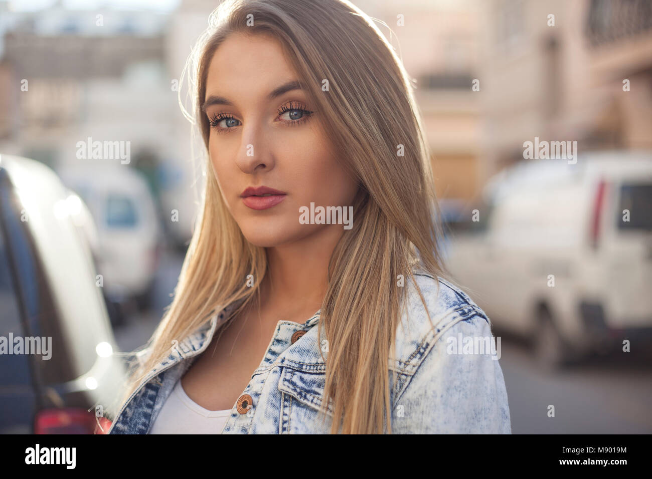 Beautiful blue eye model posing with narrow street in the background. Stock Photo