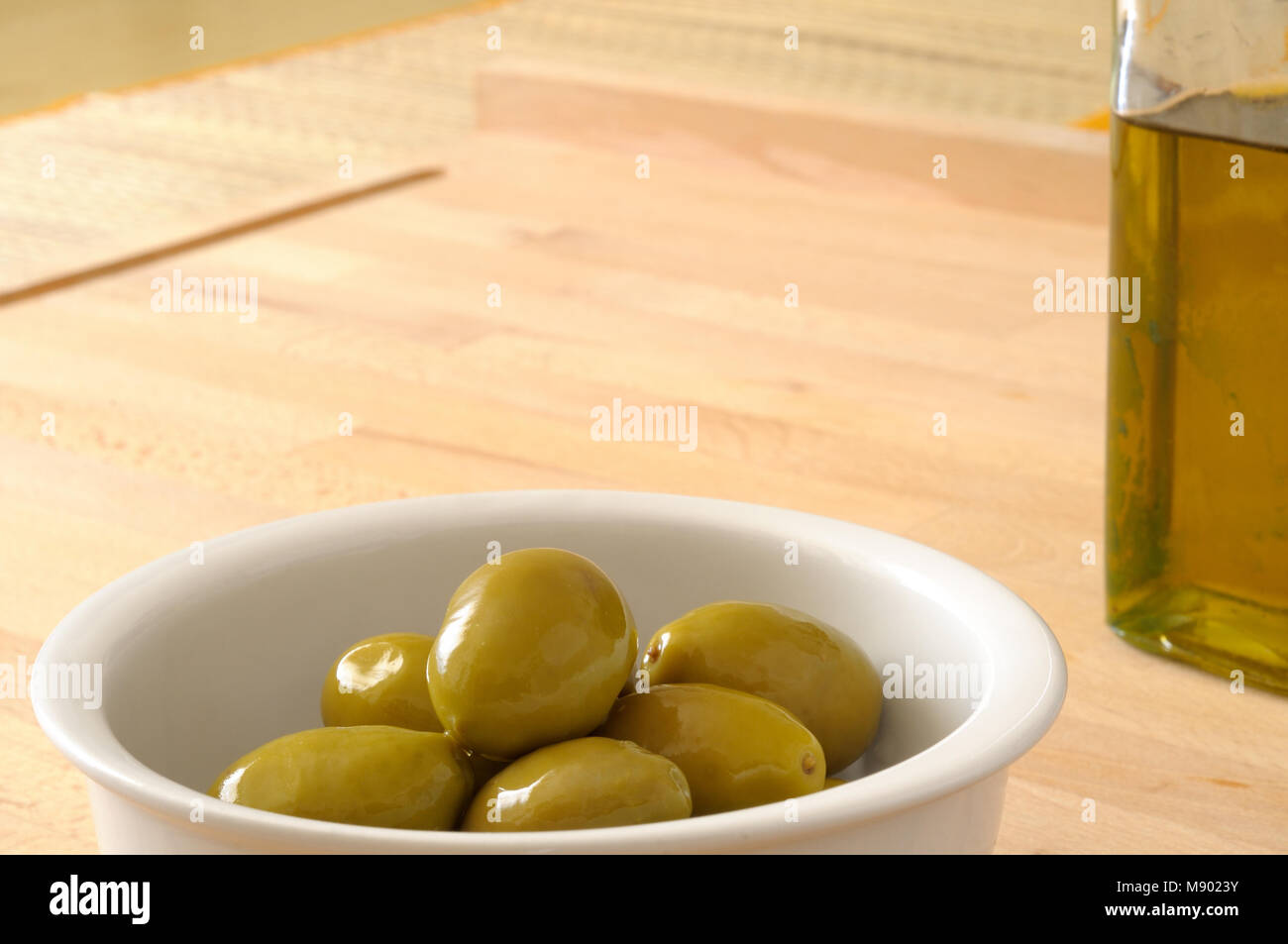 Green olives and extra virgin olive oil on the kitchen table Stock ...