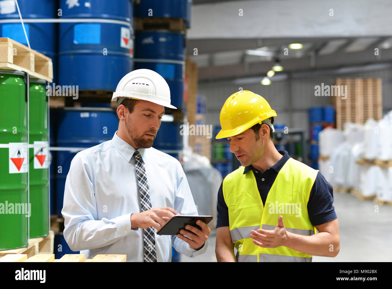 managers and workers in the logistics industry talk about working with chemicals in the warehouse Stock Photo