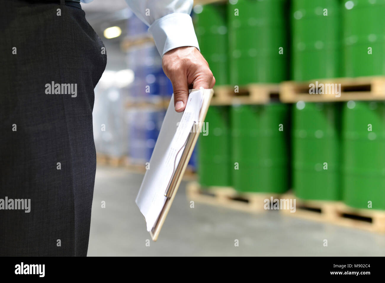 managers in a warehouse controlled by a clipboard - symbolic picture Stock Photo