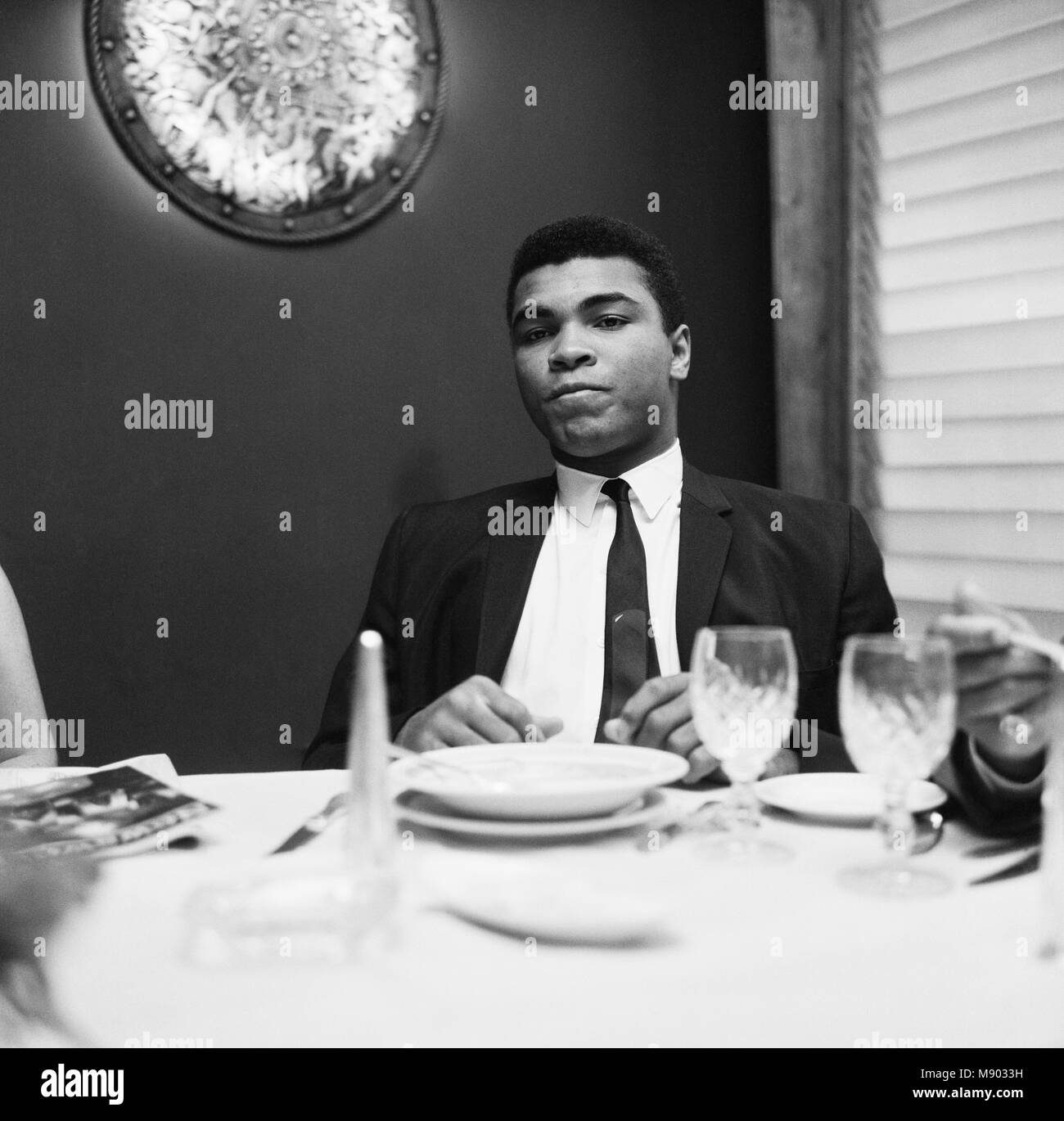 Cassius Clay (Pictured) having lunch in London before his trip to Scotland for an exhibition bout against fellow American Jimmy Ellis. However, his visit didn't go to plan after fans booed during the exhibition fight. The World Champion berated them saying: 'All booing must stop when the king's in the ring.' The visit had started on a positive note a few days earlier when Ali made a visit to Glasgow's Oakbank Hospital. He happily signed autographs for patients. 16th August 1965 Stock Photo