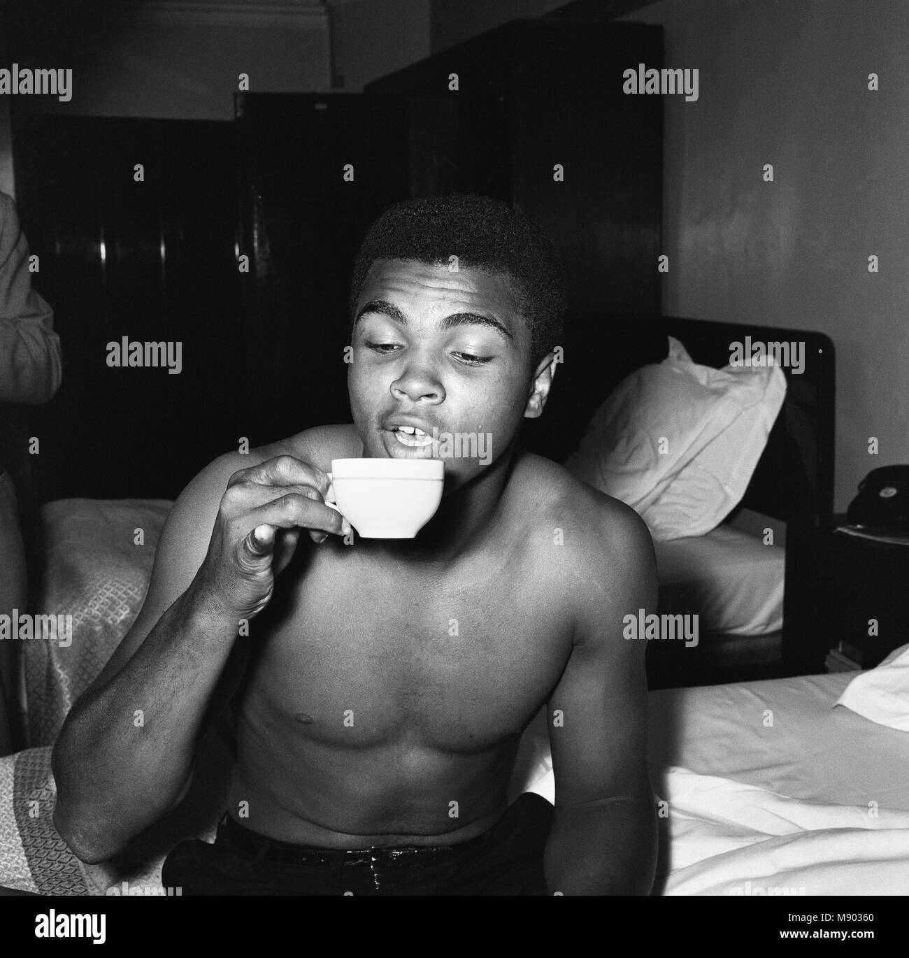 Cassius Clay (Muhammad Ali) in London ahead of his non-title fight against Henry Cooper at Wembley on 18th June. (Picture shows) Cassius drinking tea the English way with his little finger outstretched. 27th May 1963. Stock Photo