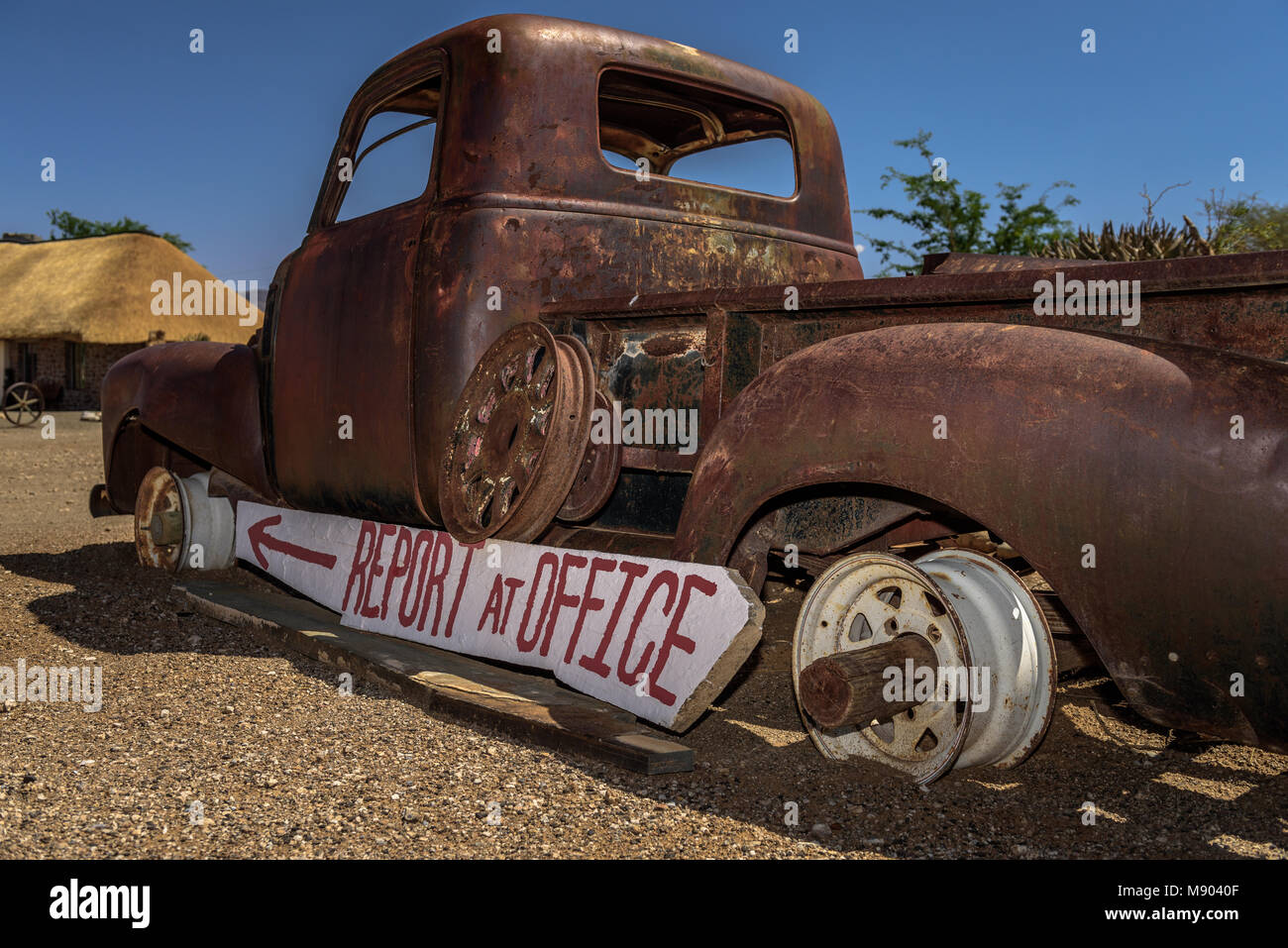 An obsolete flatbed chevrolet props up a sign at the entrance to Tsauchab river camp in Namibia Stock Photo