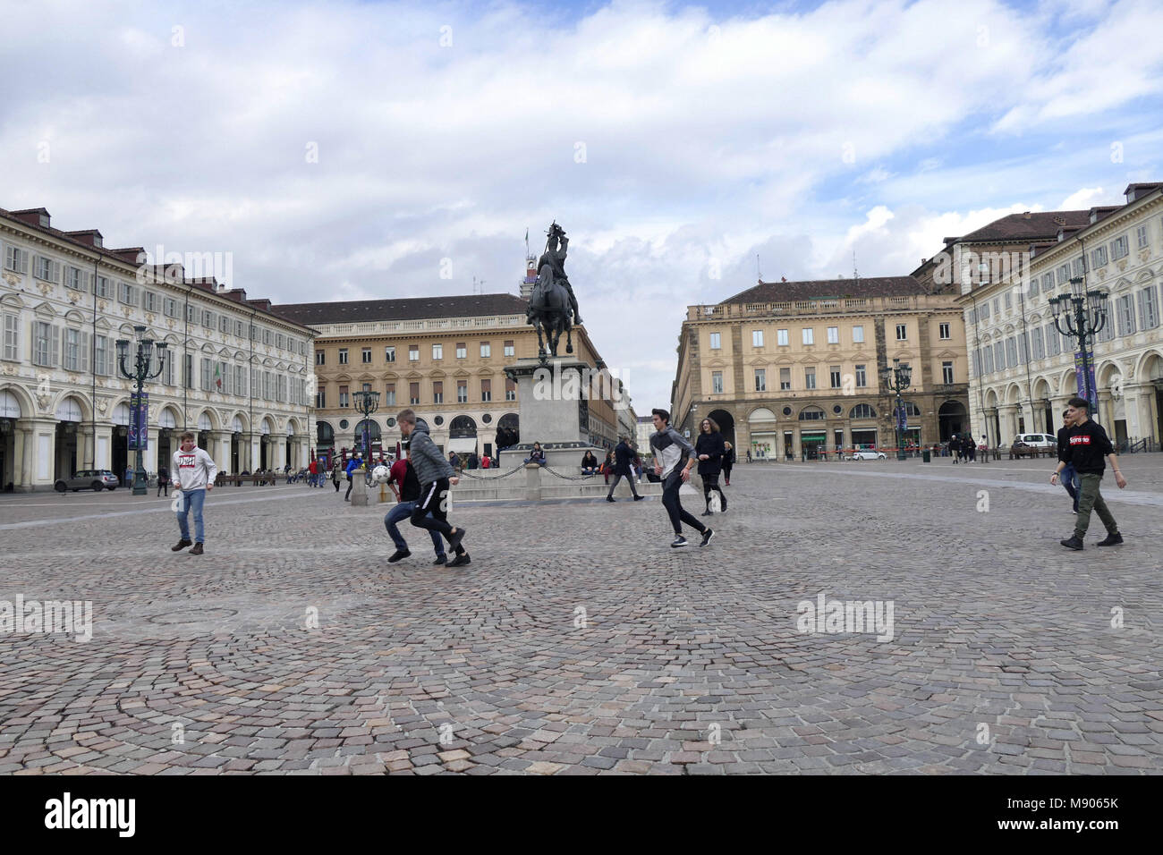 Group of teens students playing soccer in aulic San Carlo square during a break of cultural school trip Turin Italy March 12 2018 Stock Photo