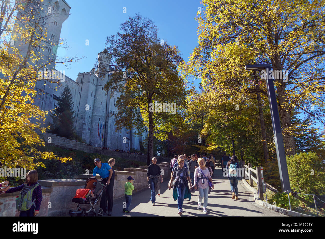 Bavaria, Germany - October 15, 2017:  Tourists walking near Neuschwanstein Castle and Alps mountains at fall Stock Photo