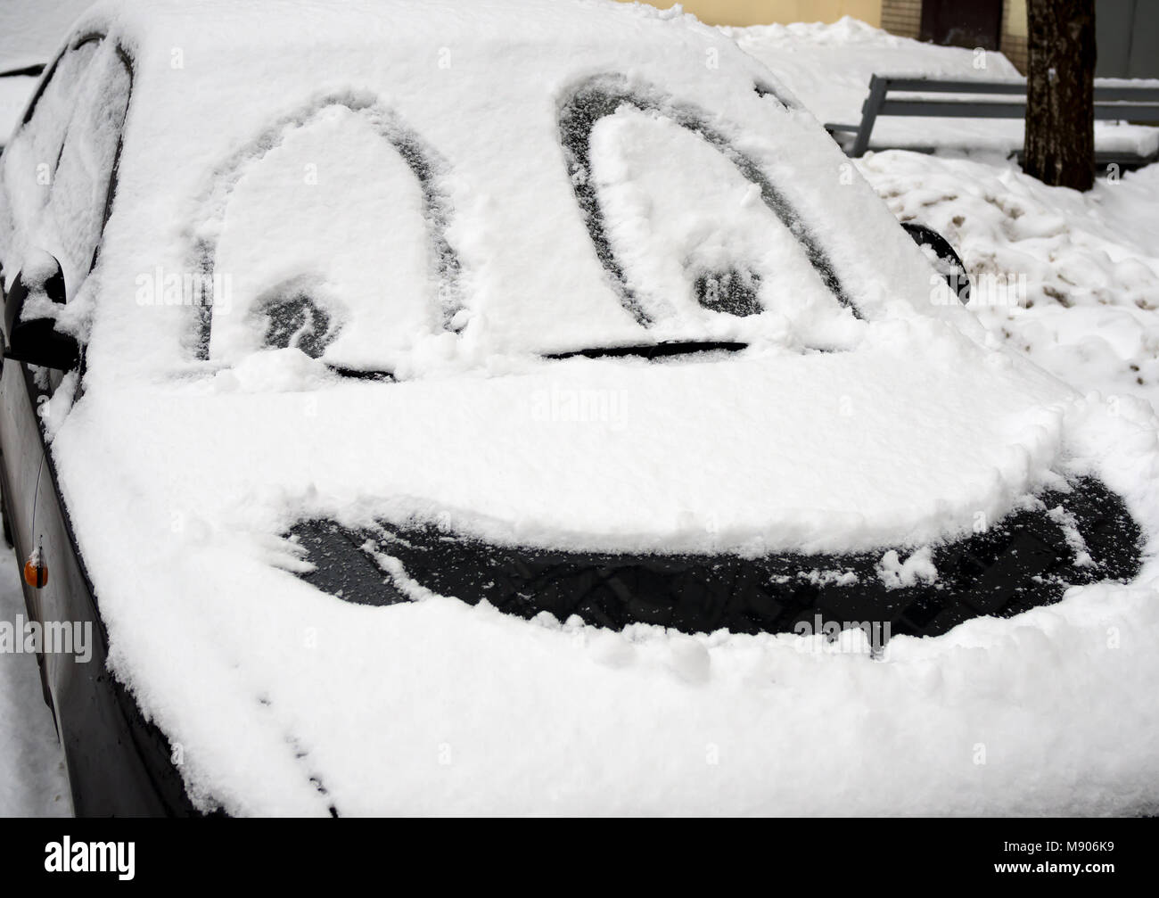 A drawn smiley face in winter on the snow-covered white color car  windshield. A graphic winter season creative scene. The positive expression  as funny Stock Photo - Alamy