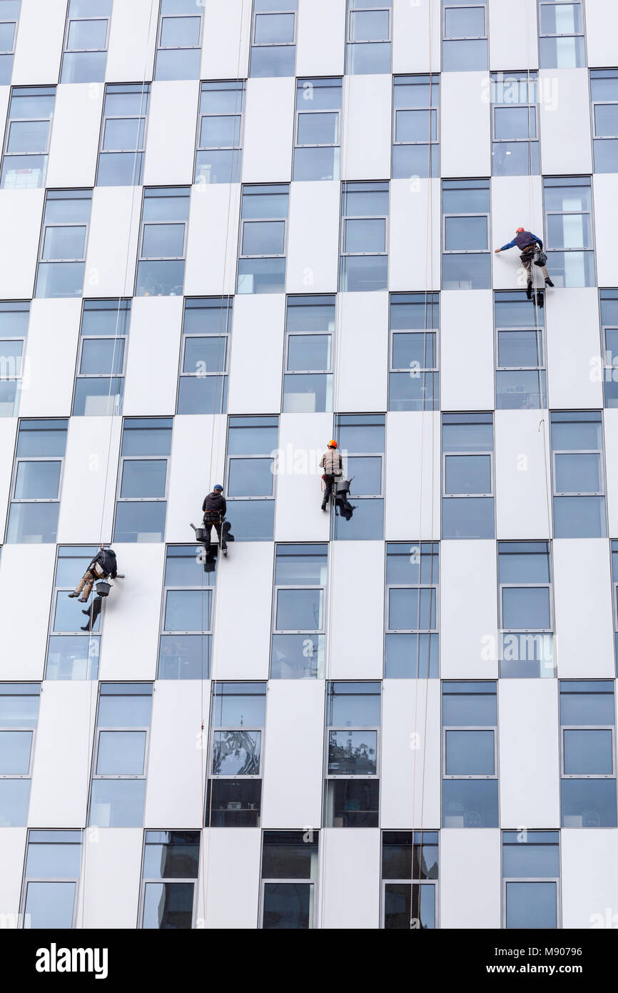 Group of workers, hanging on clambing rope, clean the windows ond outer ...