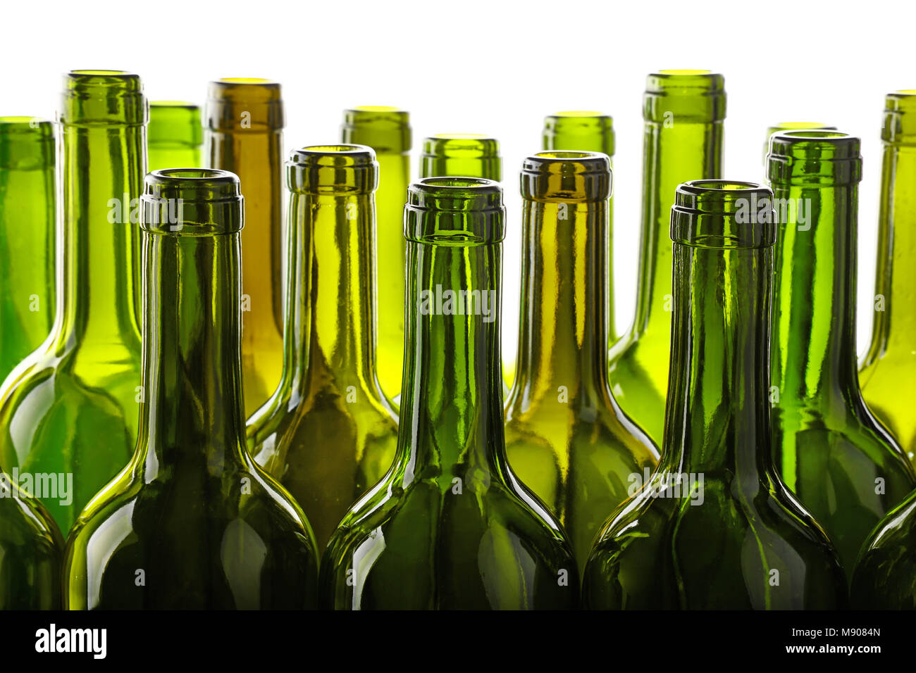 Close up group of many empty washed green glass wine bottles in a row isolated on white background, low angle side view Stock Photo