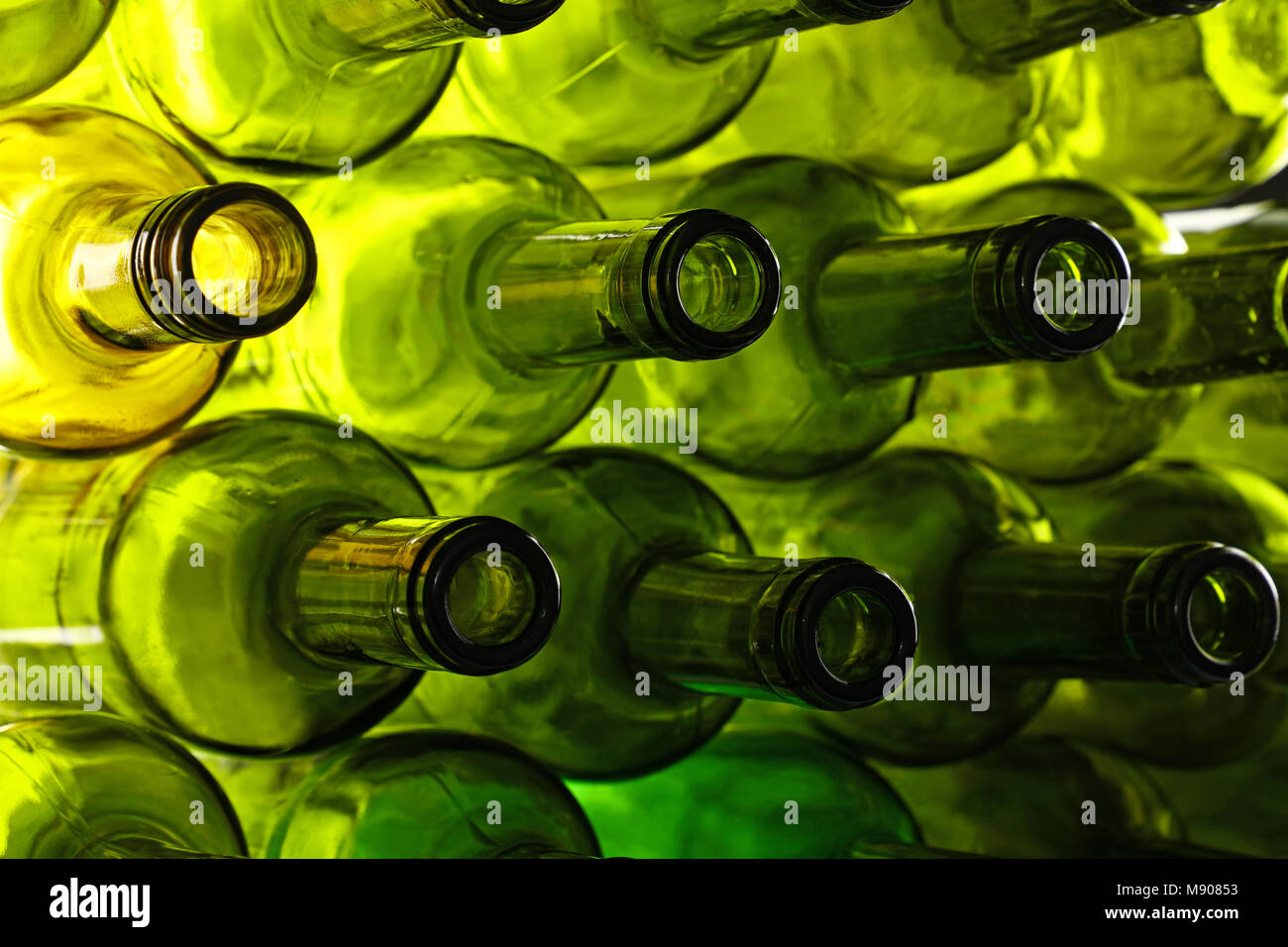 Close up stack of many empty washed green glass wine bottle necks, low angle side view Stock Photo