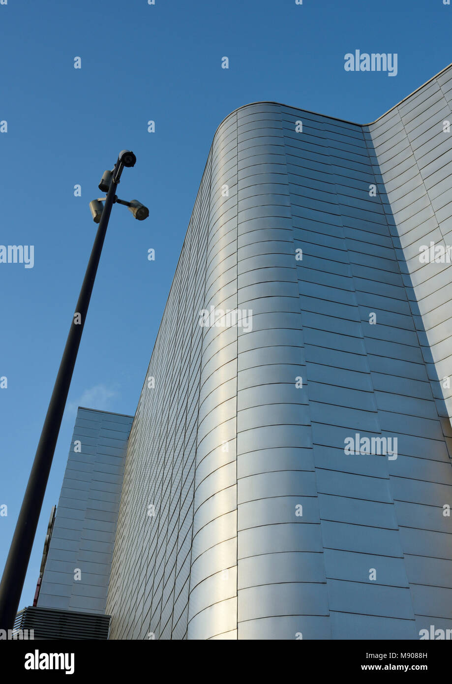 Sunlight reflecting off curved aluminium rainscreen cladding on corner ...