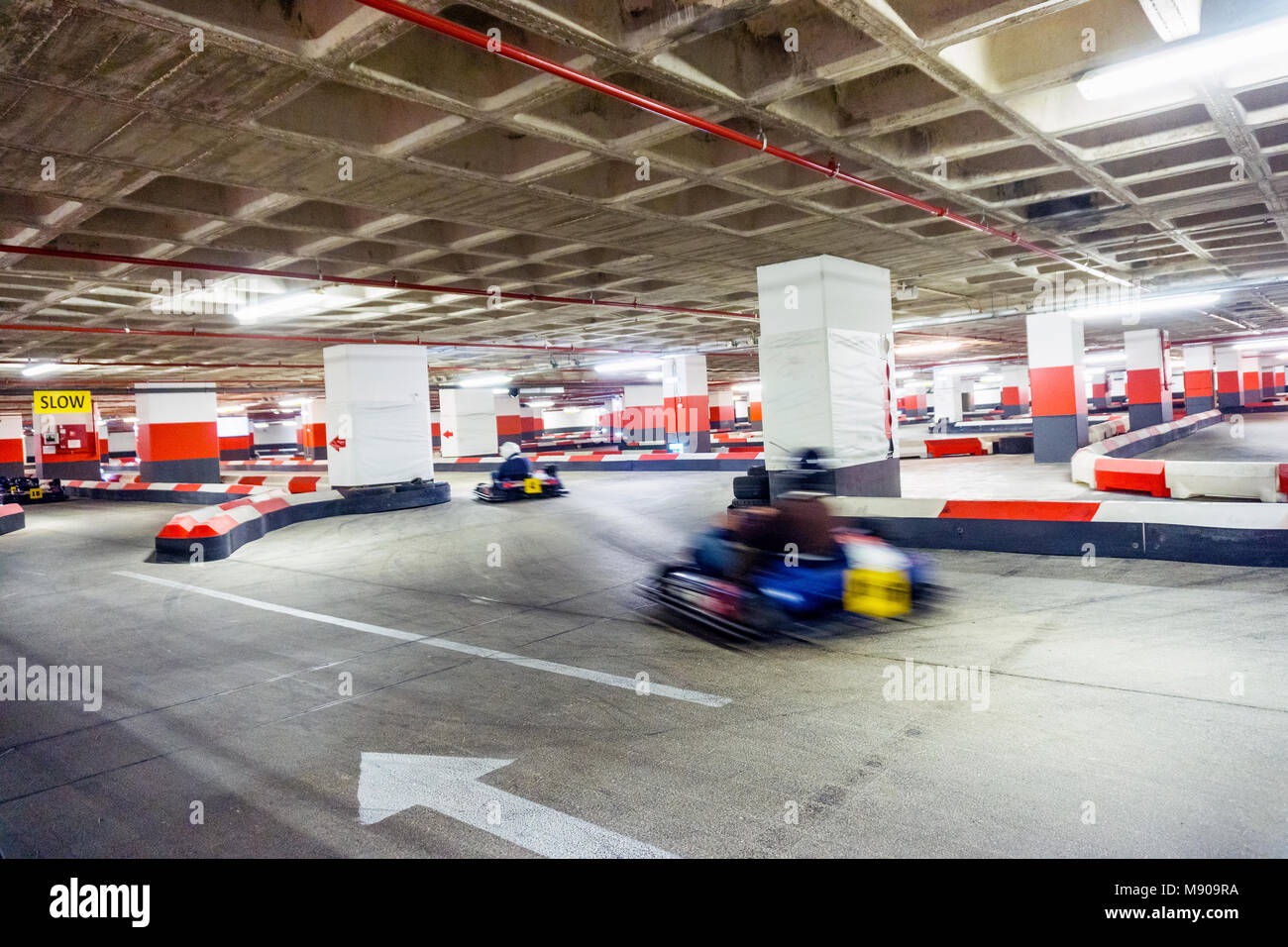 Two people racing on indoor karting track located in underground parking lot Stock Photo