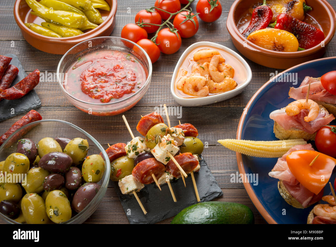 Mixed spanish tapas starters on table. Open sandwiches, shrimps, olives, grilled pepper, pickled