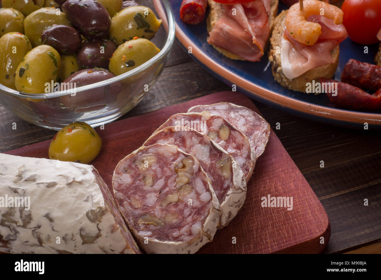 Sharing mixed spanish tapas starters on table. Olives, sandwiches ...