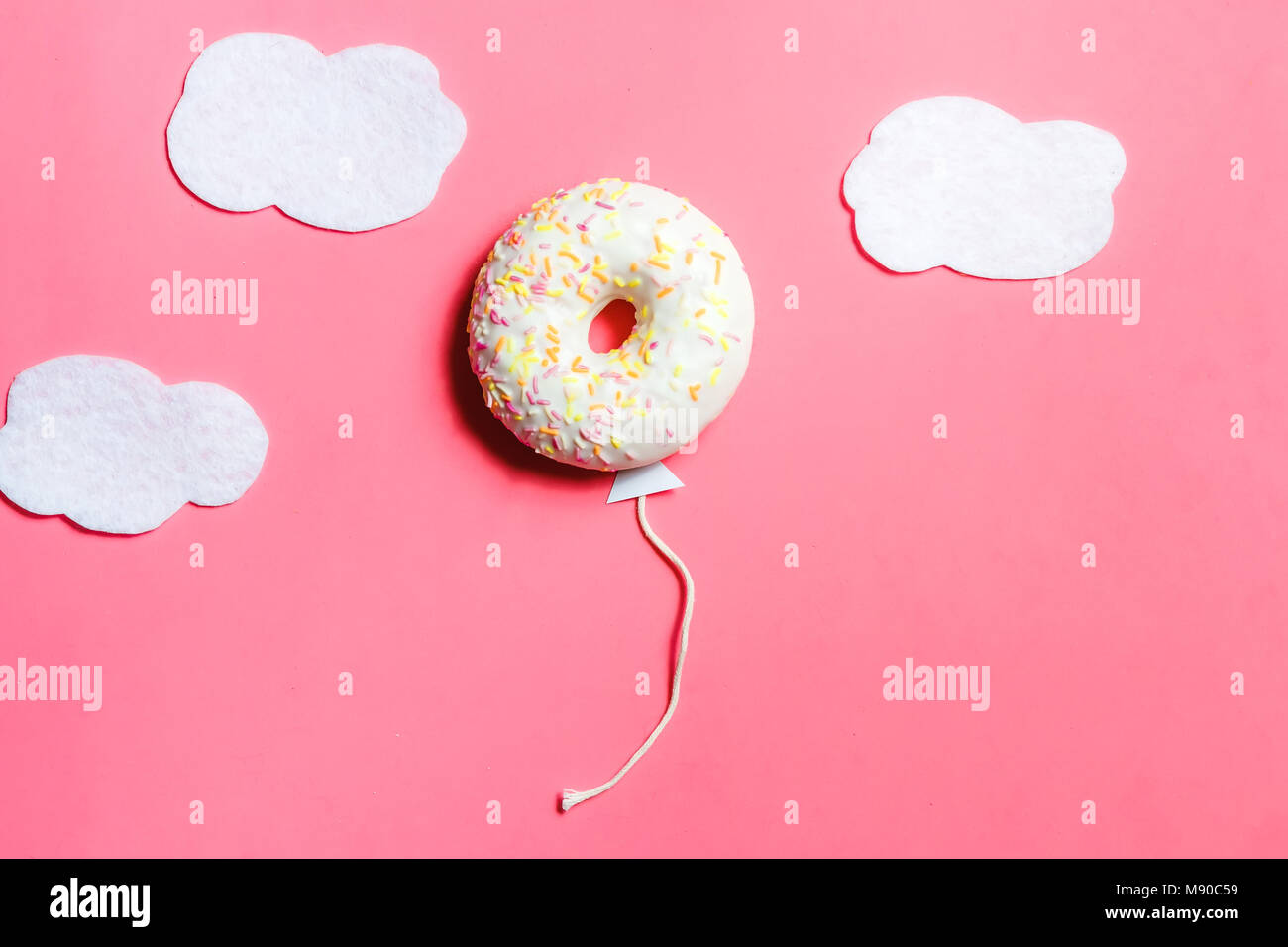 Donut on Pink Background, Creative Food Minimalism, Donut in Shape of Balloon in Sky with Clouds, Top View with Copy Space, Toned Stock Photo