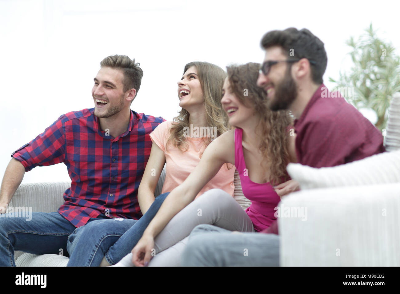 group of cheerful friends sitting on the couch in the living room Stock ...
