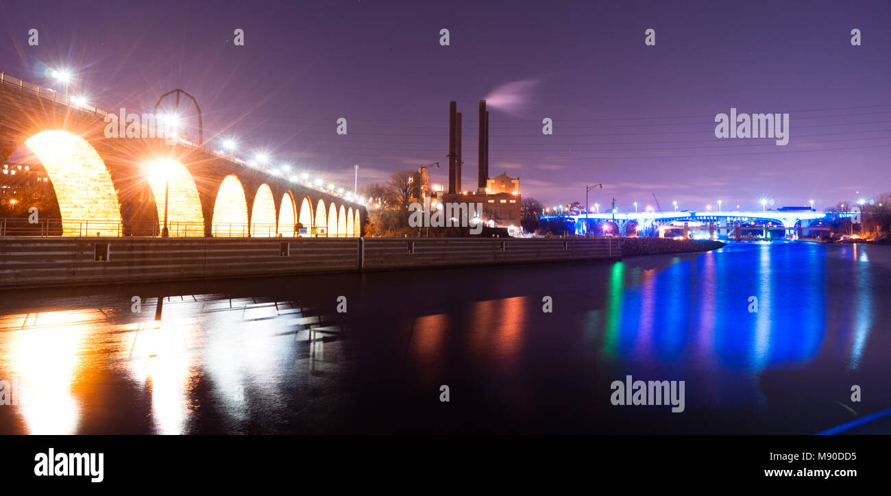 The Mississippi River slowly flows under the bridge at the St Paul Minnesota waterfront Stock Photo