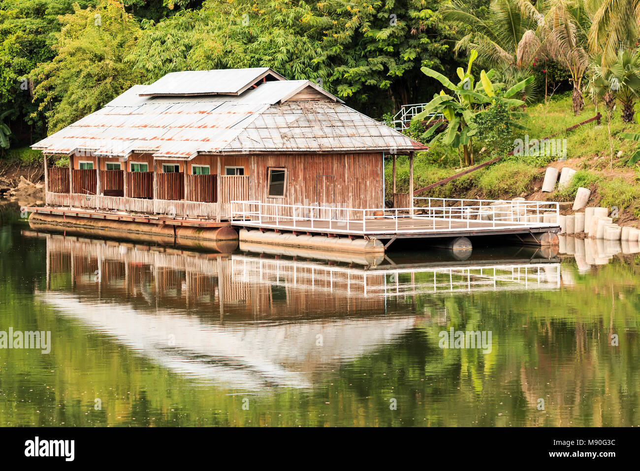 Floating house and reflection on the River Kwai in Kanchanaburi