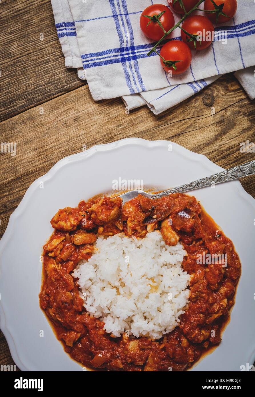 Traditional indian cuisine. Spicy tikka masala with rice on wood table top view Stock Photo