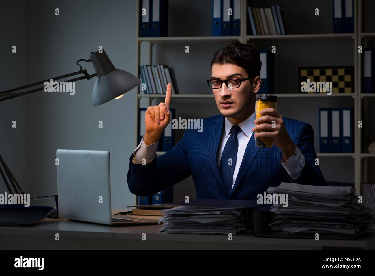 Employee Working Late And Drinking Strong Coffee To Stay Awake