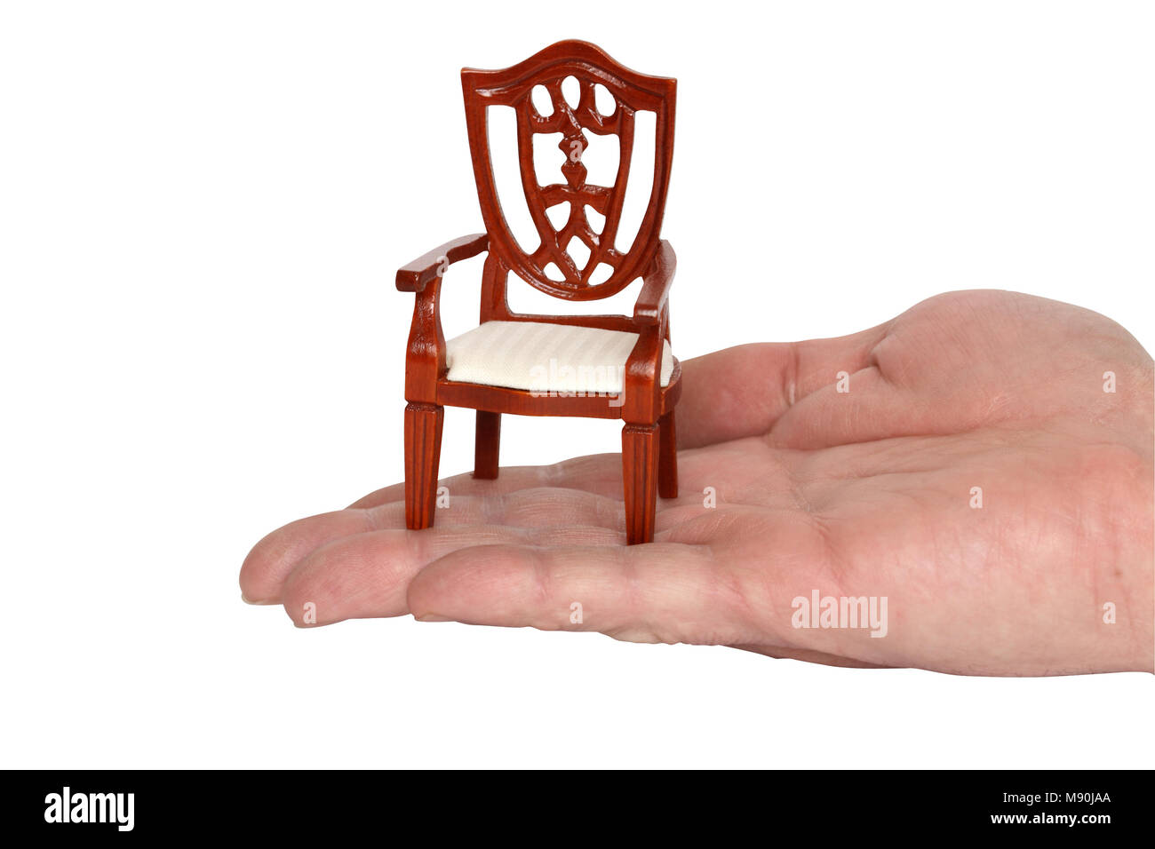 Miniature toy chair standing on human palm. Isolated with clipping path Stock Photo