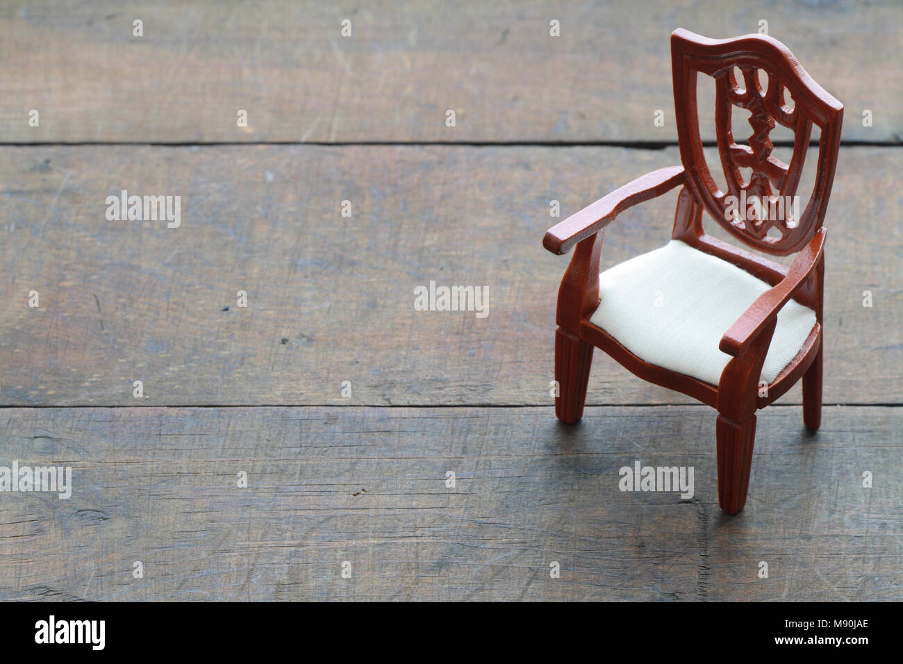 Toy wooden chair standing on wooden background with copy space Stock Photo