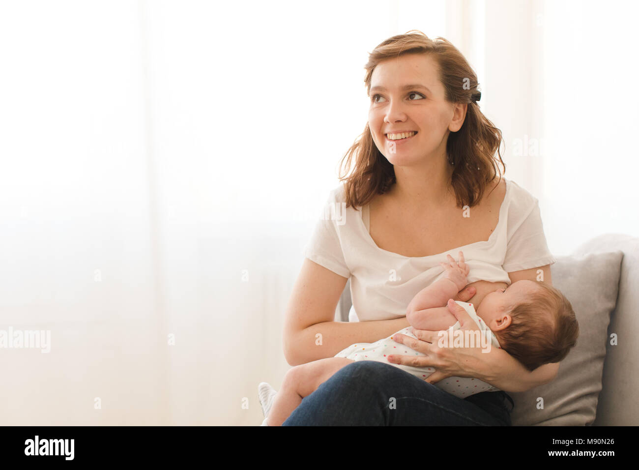Cheerful woman breastfeeding child Stock Photo