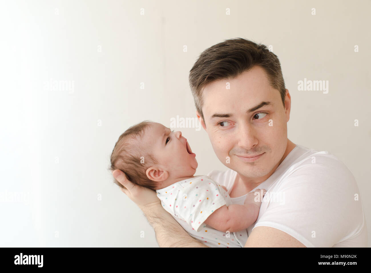 Cheerful man with screaming baby Stock Photo