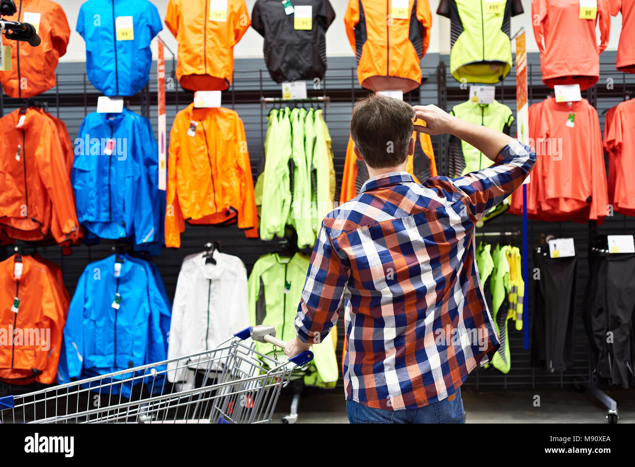 Man chooses sports clothes in a store Stock Photo