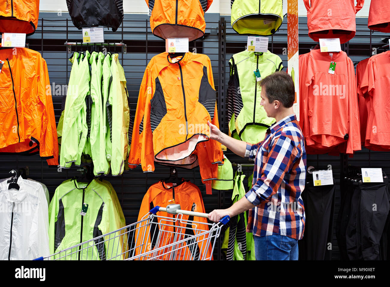 Man chooses sports clothes in a store Stock Photo