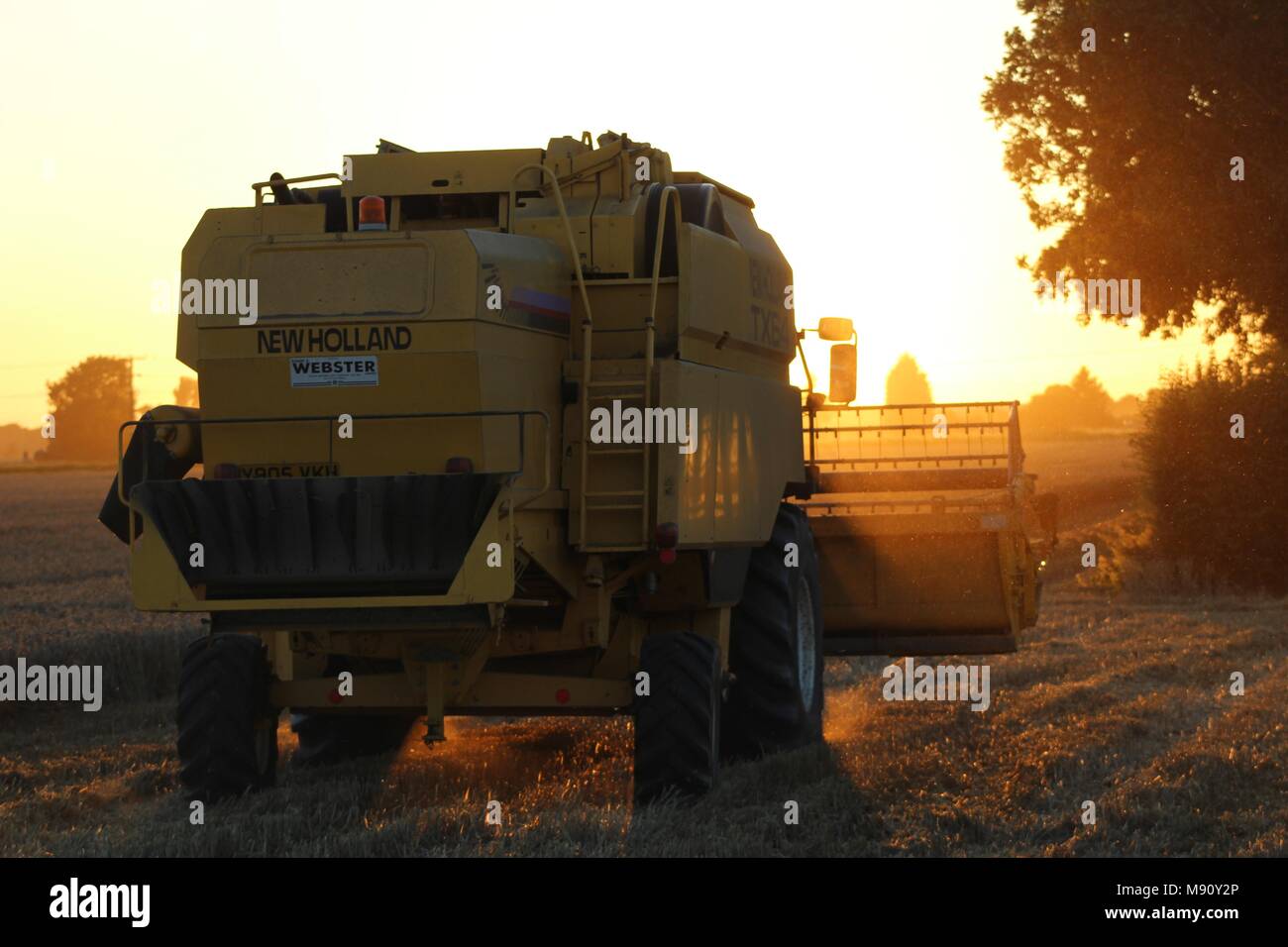 Combine Harvester working at sunset on the Farm, Yorkshire, UK Stock Photo