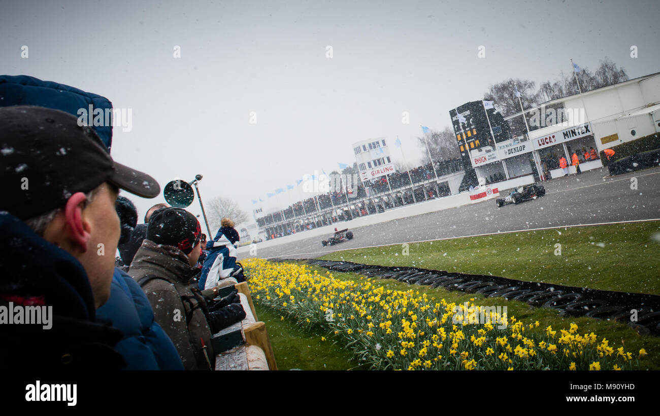 Formula 5000 racing cars go past the Pit Lane in the snow during the 2018 Goodwood Members Meeting 76MM demonstration drive. Stock Photo