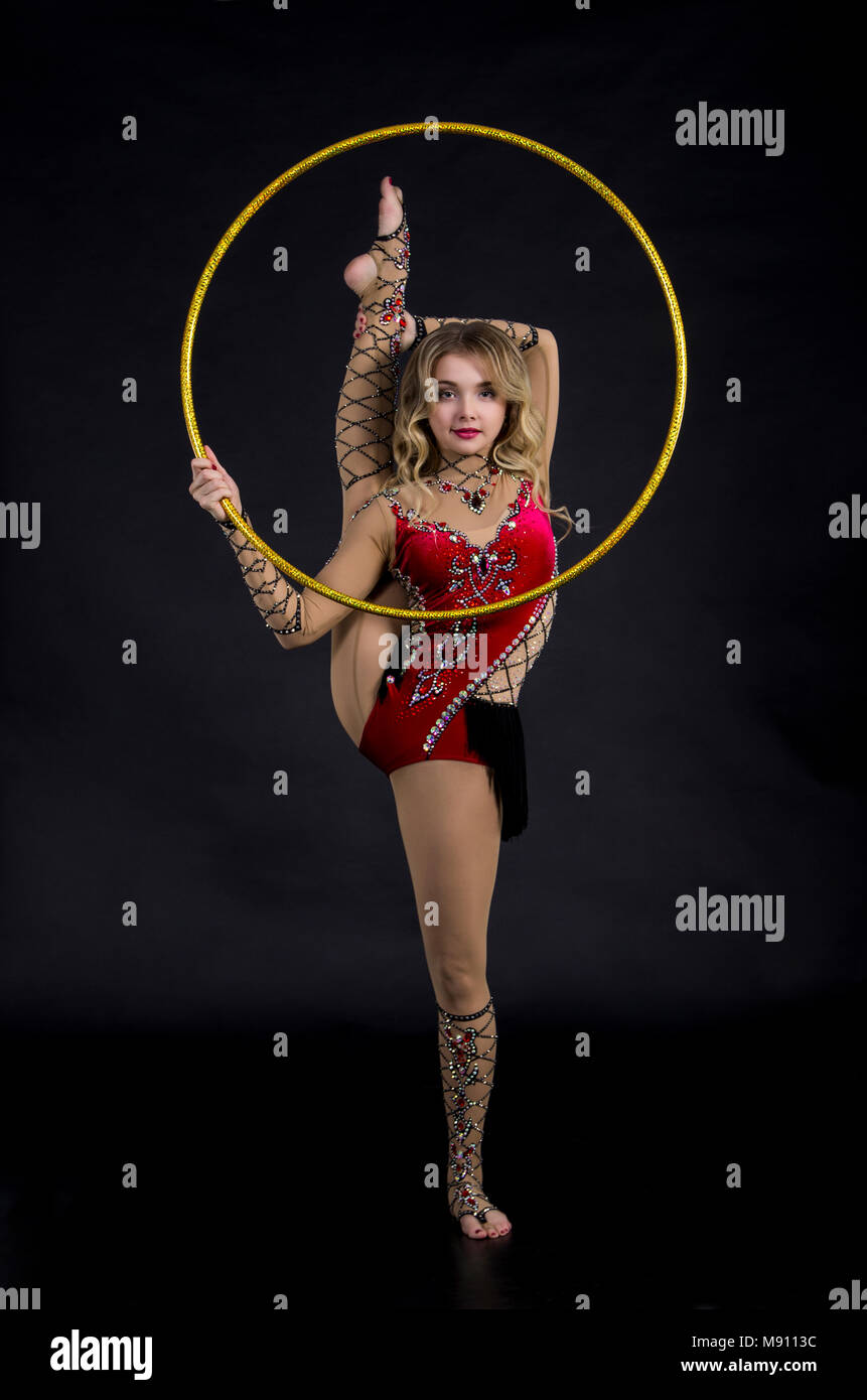 The contortionist woman in stage costume with hoops. Studio shot on dark  background Stock Photo - Alamy